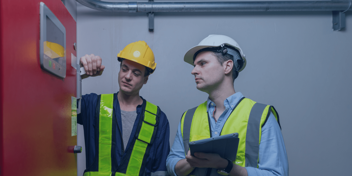 dois homens com colete e capacete técnicos de segurança avaliando a rede de incêndio