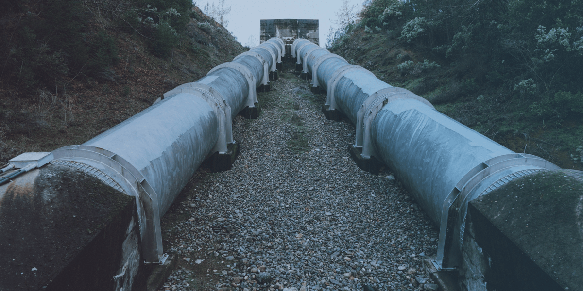 duas tubulações extensas no chão em uma área externa